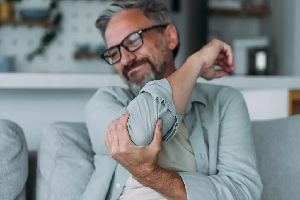 man showing us he has elbow pain