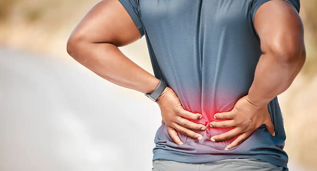 person grabbing lower back in pain